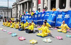 '来自英国各地的法轮功学员，欢聚伦敦市中心的“鸽子广场”庆祝大法洪传二十周年并祝贺师父生日。'